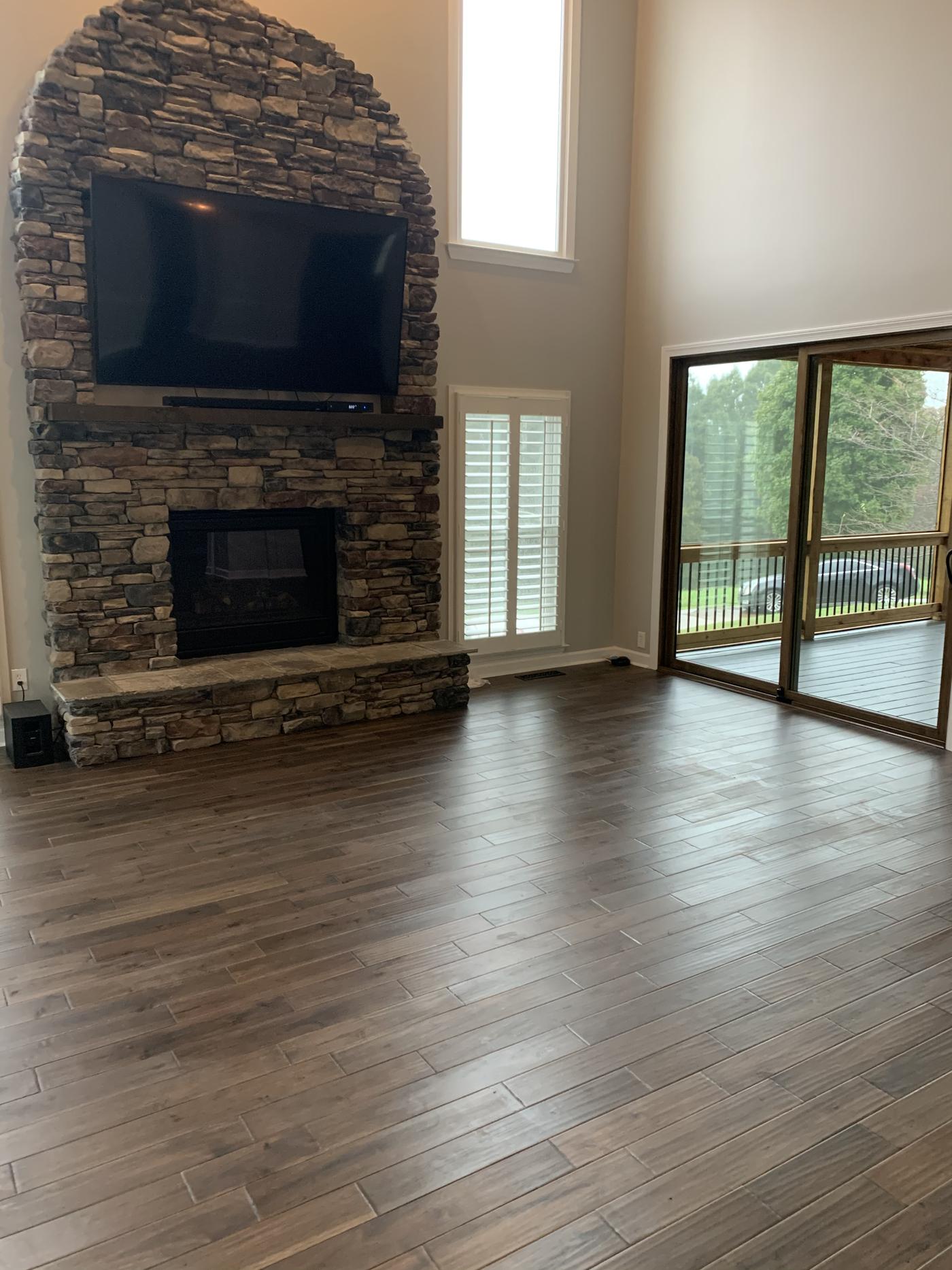 Great room with a stone fireplace and hardwood floors