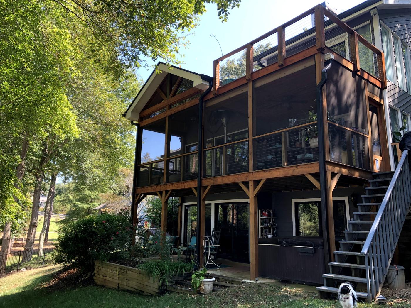 Two-story screened porch with cedar posts and cable railing, built by EBD Construction
